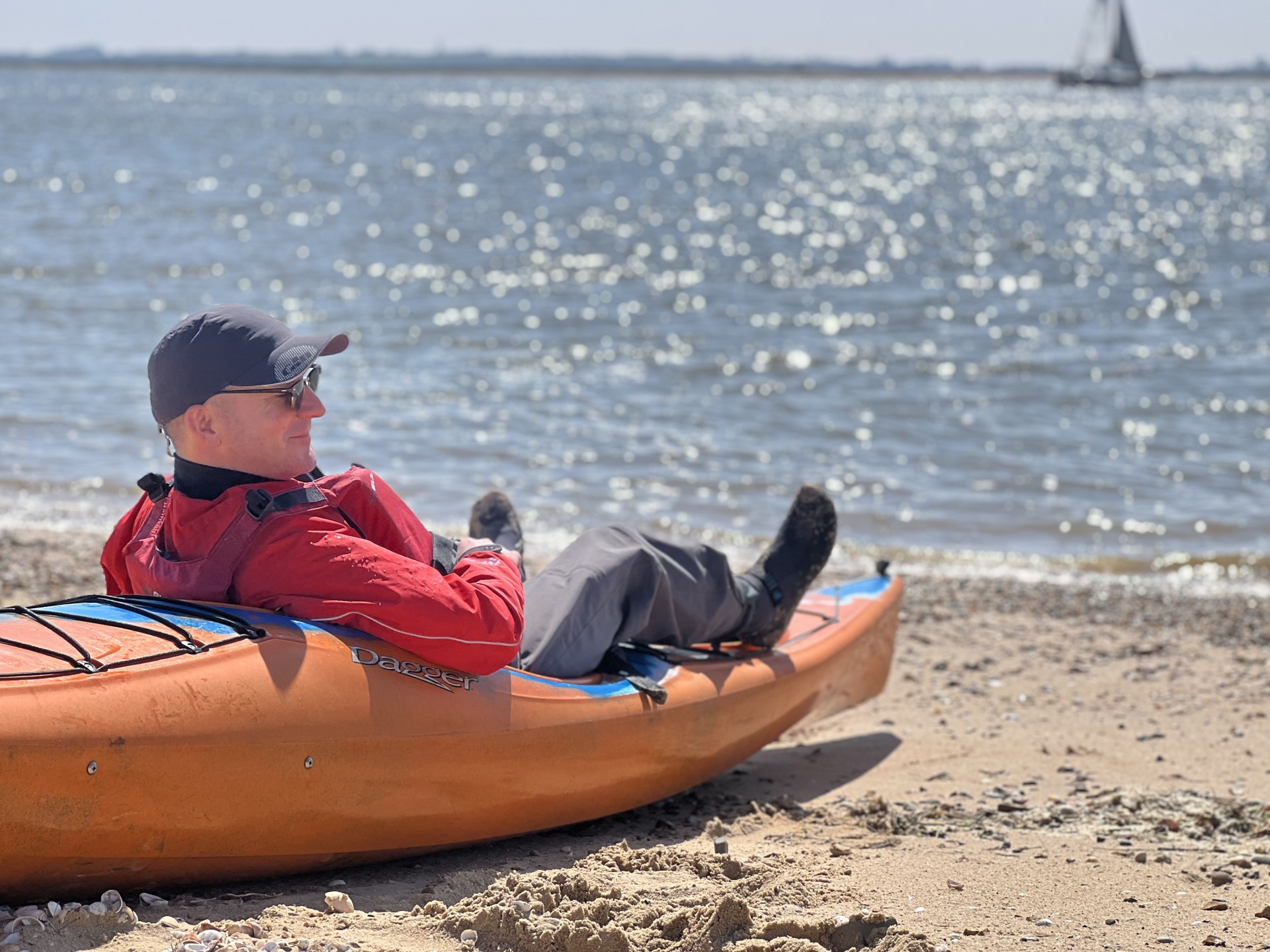 Kayaker relaxing in the summer sunshine with NOMAD Sea Kayaking.