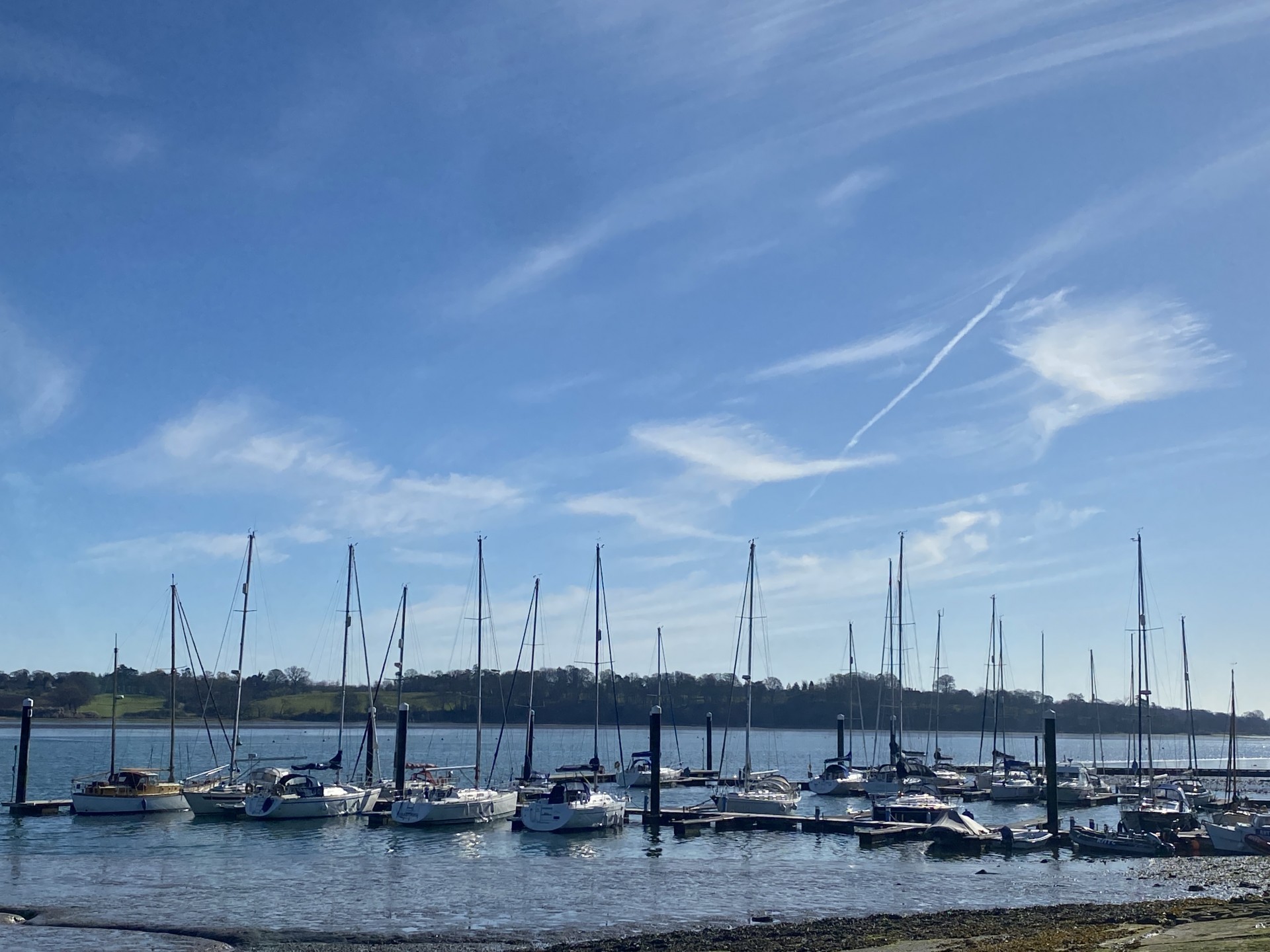 Yachts on their moorings with a blue sky on a bright and sunny day.